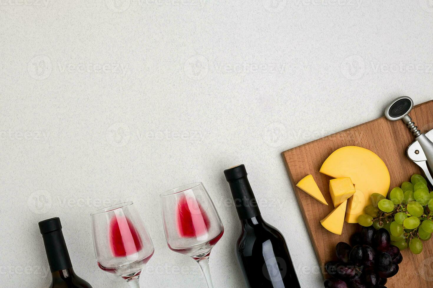 Glasses and bottles of red and white wine on white background from top view photo