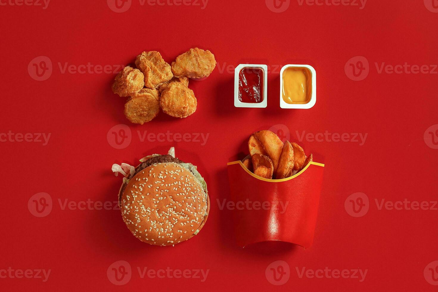 Burger and Chips. Hamburger and french fries in red paper box. Fast food on red background. photo