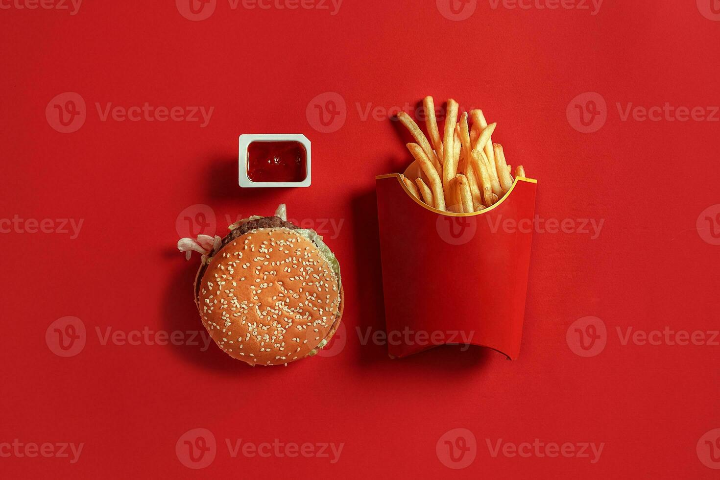 Burger and Chips. Hamburger and french fries in red paper box. Fast food on red background. photo