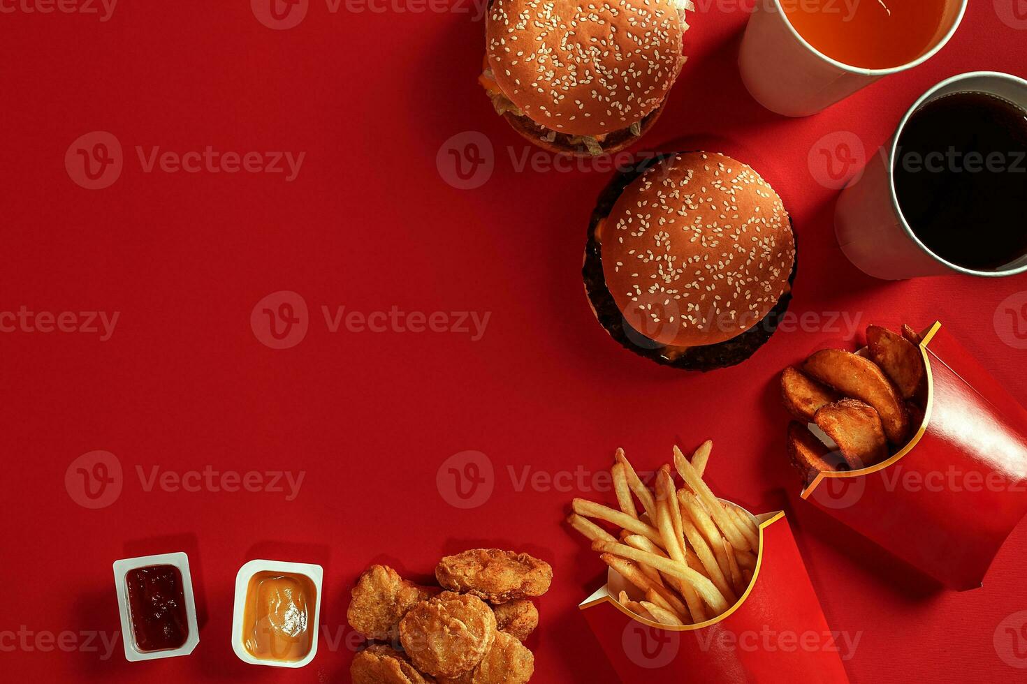 Fast food dish top view. Meat burger, potato chips and glass of drink on red background. Takeaway composition. photo