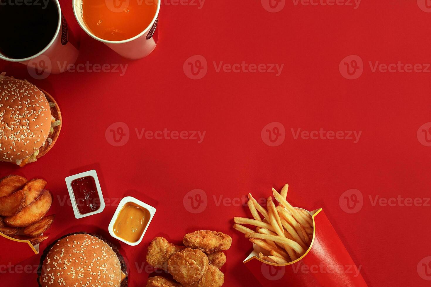 Fast food dish top view. Meat burger, potato chips and glass of drink on red background. Takeaway composition. photo