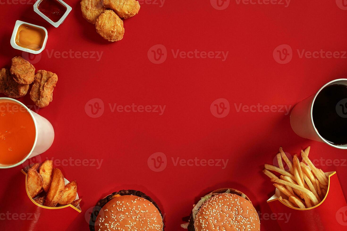 Fast food dish top view. Meat burger, potato chips and glass of drink on red background. Takeaway composition. photo