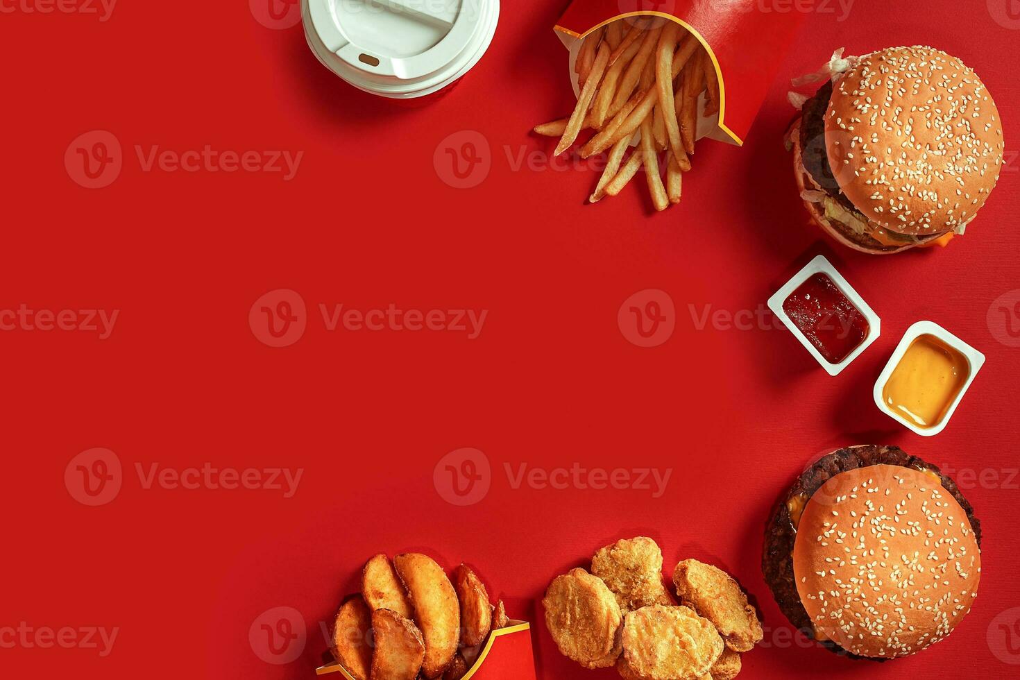 Fast food dish top view. Meat burger, potato chips and glass of drink on red background. Takeaway composition. photo