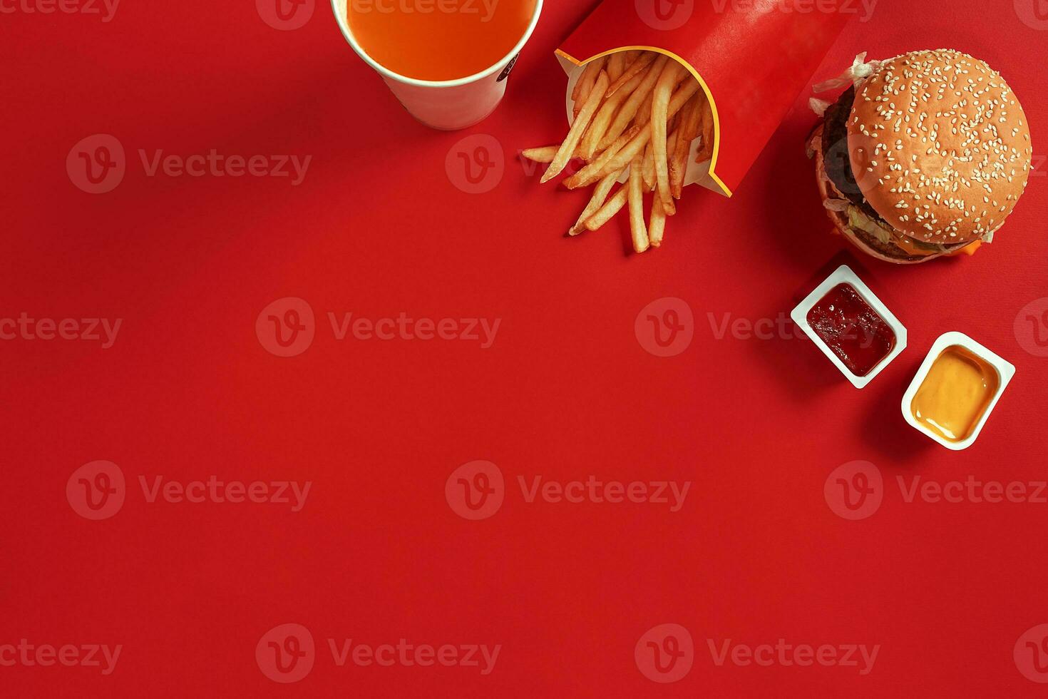 Fast food dish top view. Meat burger, potato chips and glass of drink on red background. Takeaway composition. photo