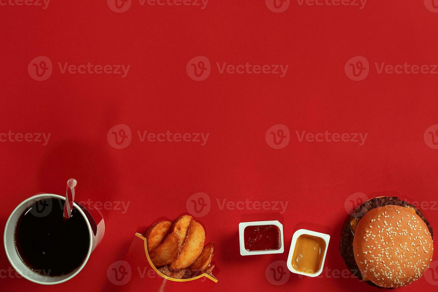 Concept of mock up burger, potatoes, sauce and drink on red background. Copy space for text and logo. photo