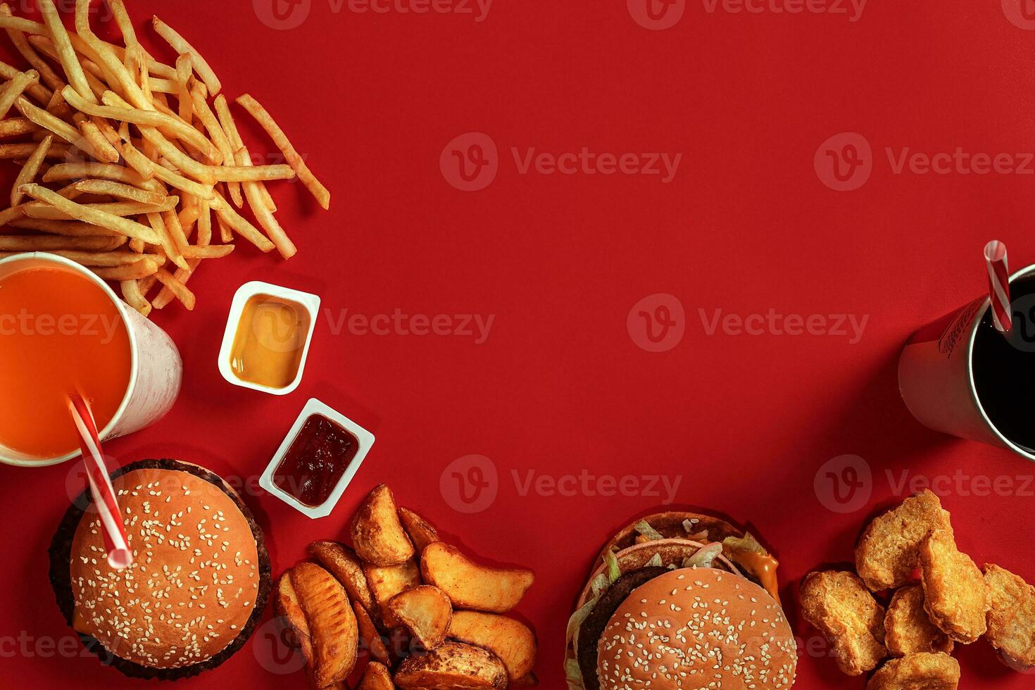 Fast food dish top view. Meat burger, potato chips and glass of drink on red background. Takeaway composition. photo