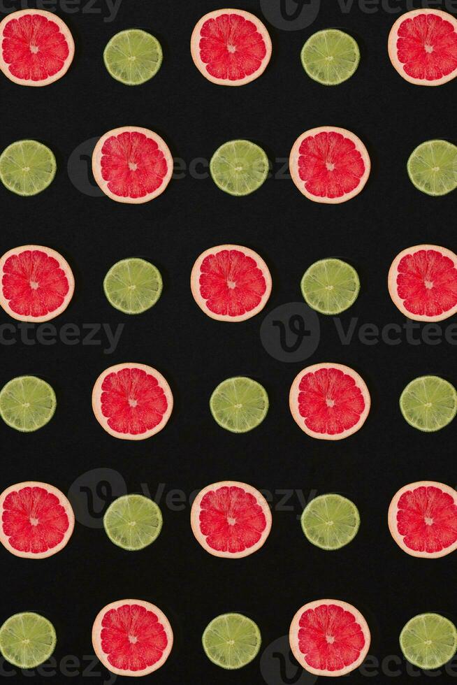 Grapefruit and lemon pattern isolated on black background. Flat lay photo