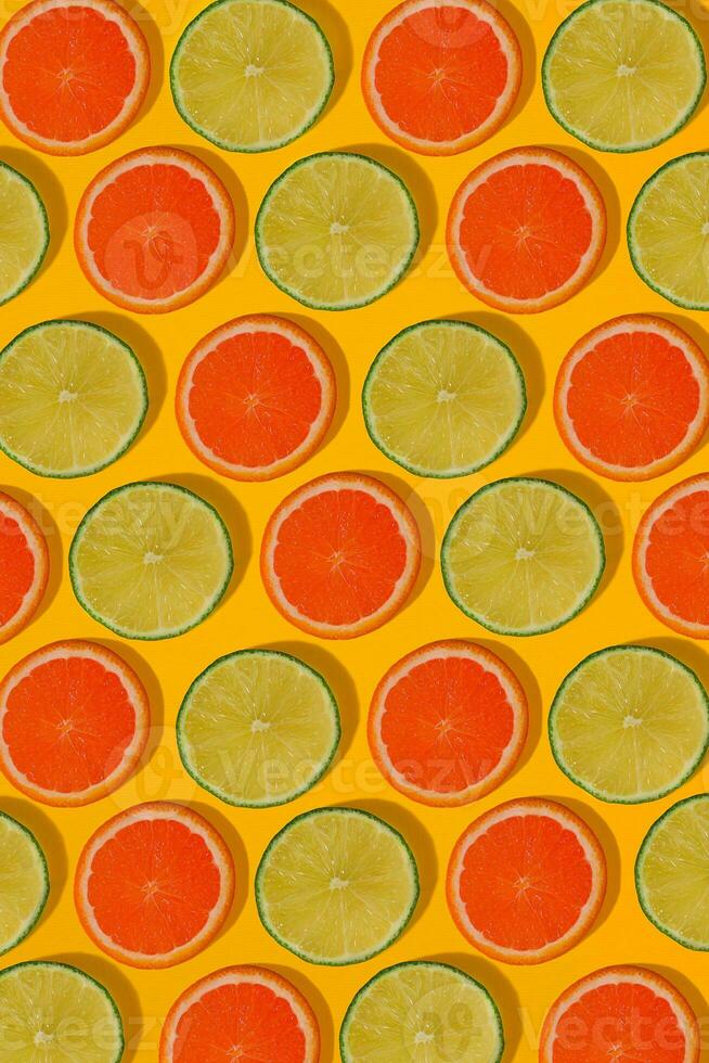 Grapefruit and lime pattern on yellow background. Minimal flat lay concept. photo