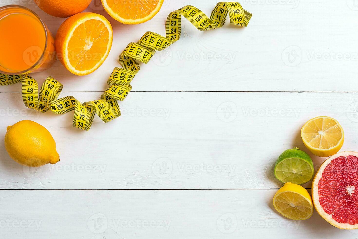 Fresh fruits with tape measure over white wooden background. Top view photo