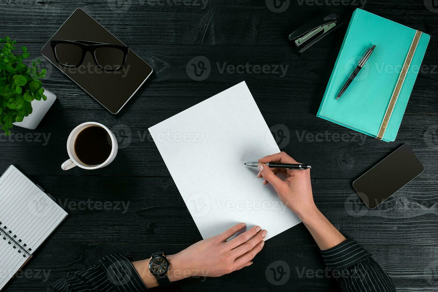 Overhead view of businesswoman working at computer in office against a dark background photo
