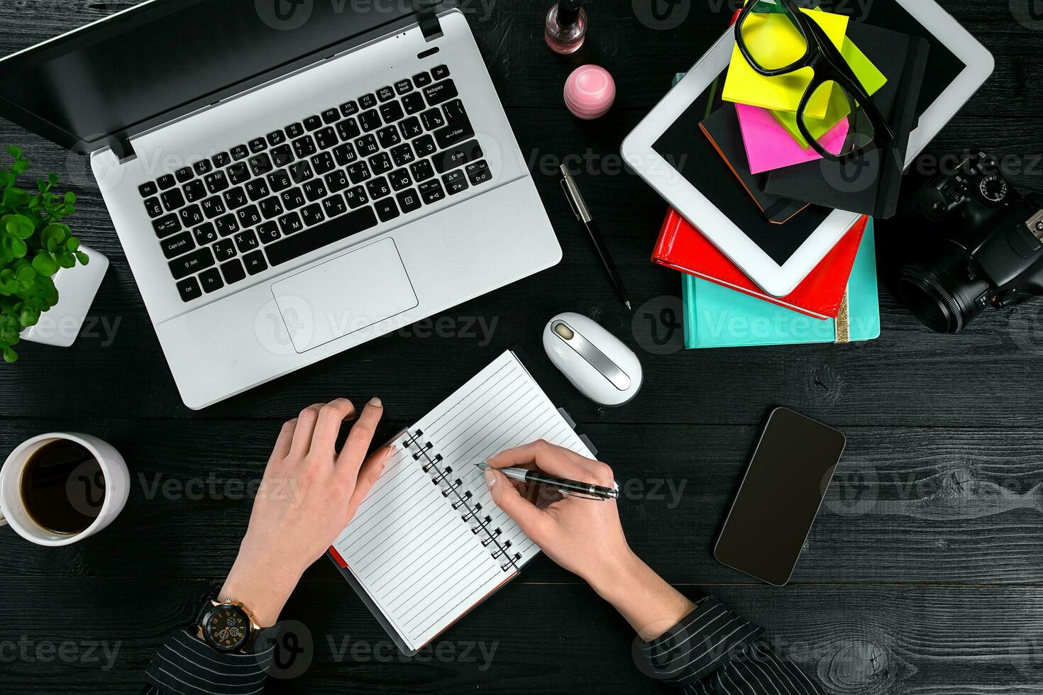 Mix of office supplies and gadgets on a wooden desk background. View from above. photo