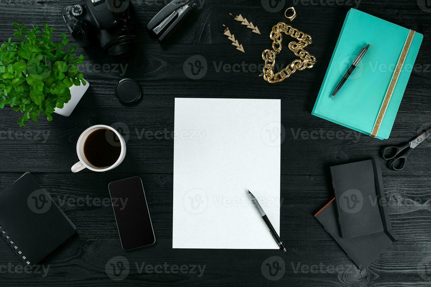 Flat lay, top view office table desk frame. Workspace with clean sheet of paper, mint diary and mobile device on dark background. photo