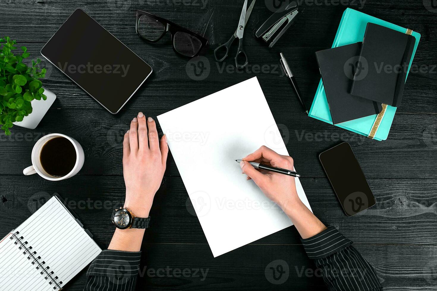 Mix of office supplies and gadgets on a wooden desk background. View from above. photo