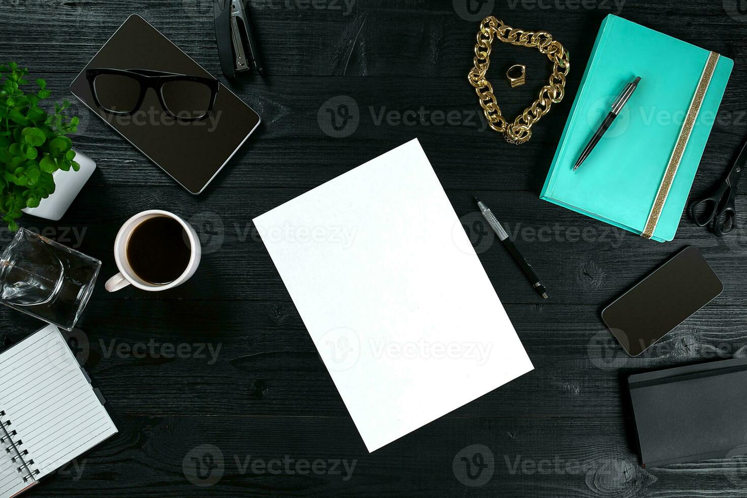 Flat lay, top view office table desk frame. Workspace with clean sheet of paper, mint diary and mobile device on dark background. photo