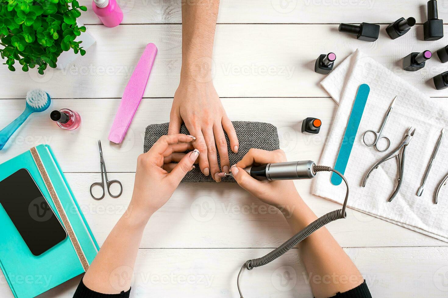 Closeup shot of a woman in a nail salon receiving a manicure by a beautician with nail file. Woman getting nail manicure. photo