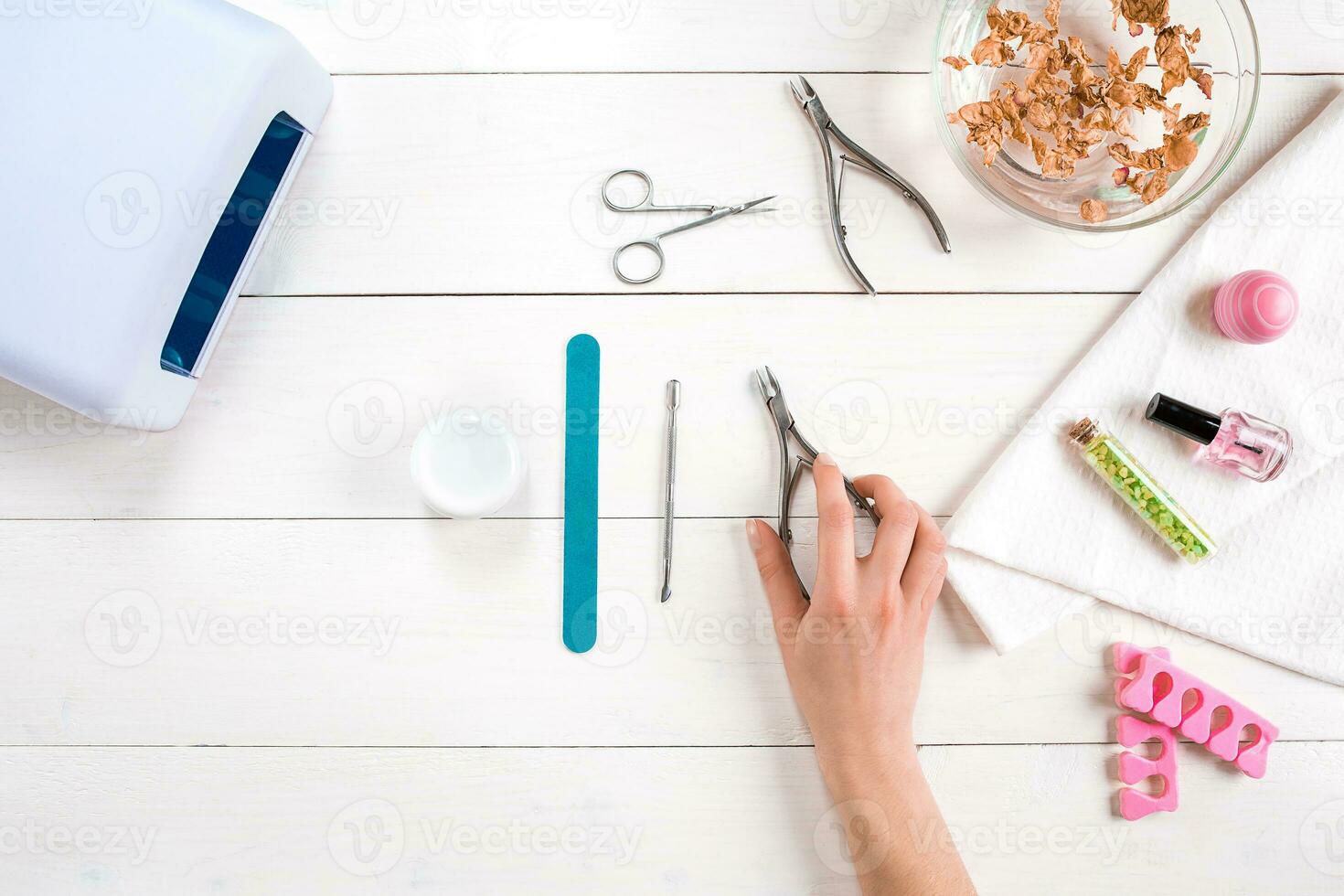 Woman Hands Care. Top View Of Beautiful Smooth Woman's Hands With Professional Nail Care Tools For Manicure On White Background. photo