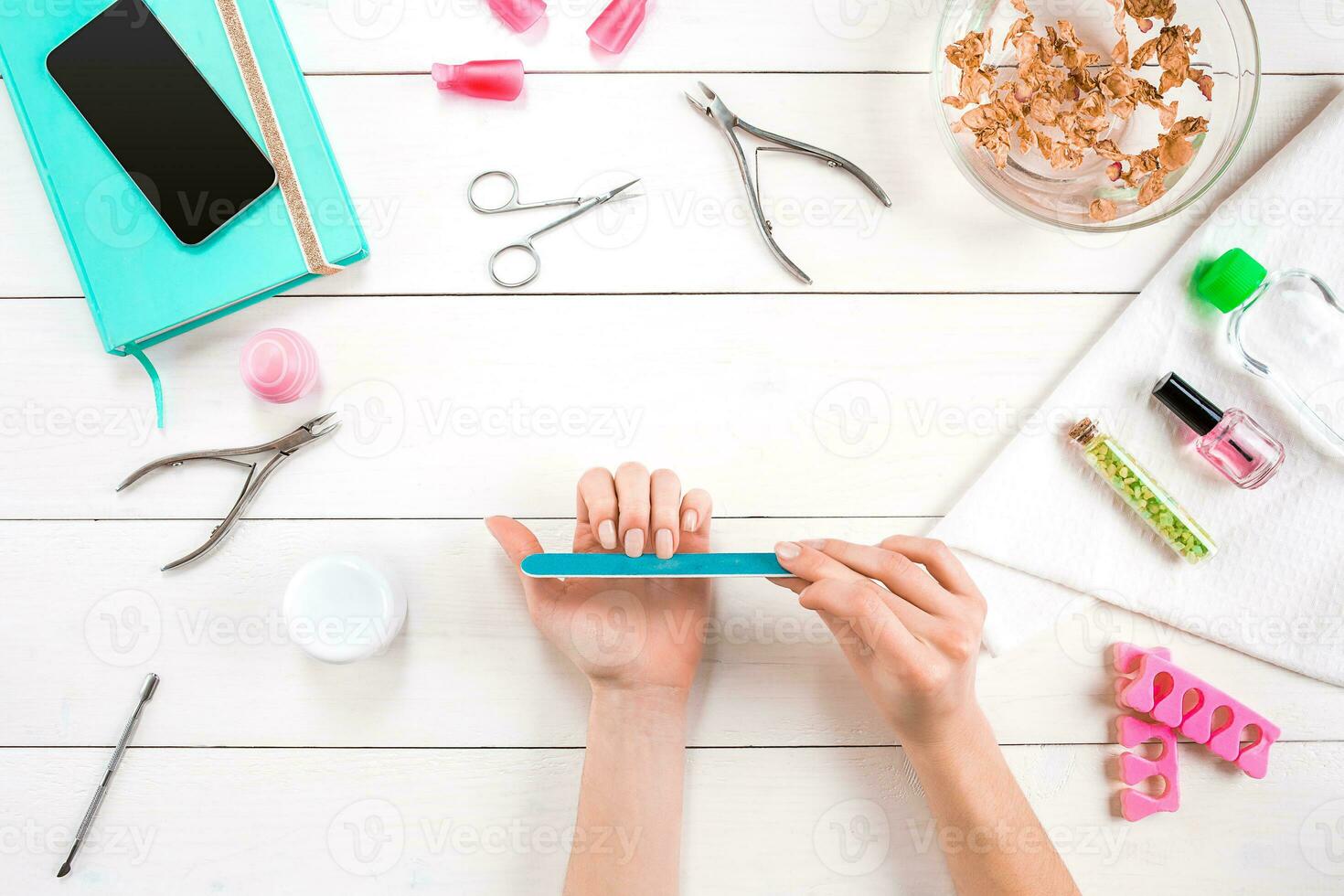 Woman Hands Care. Top View Of Beautiful Smooth Woman's Hands With Professional Nail Care Tools For Manicure On White Background. photo