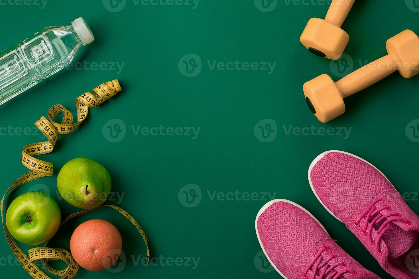 Athlete's set with female clothing and bottle of water on green background photo