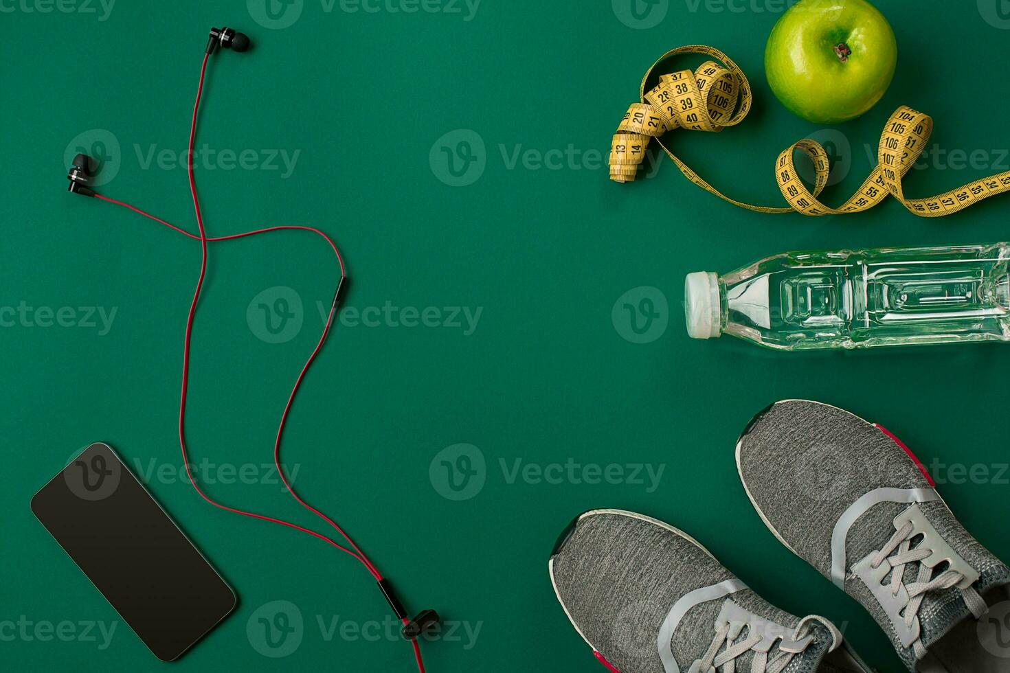Athlete's set with female clothing and bottle of water on green background photo