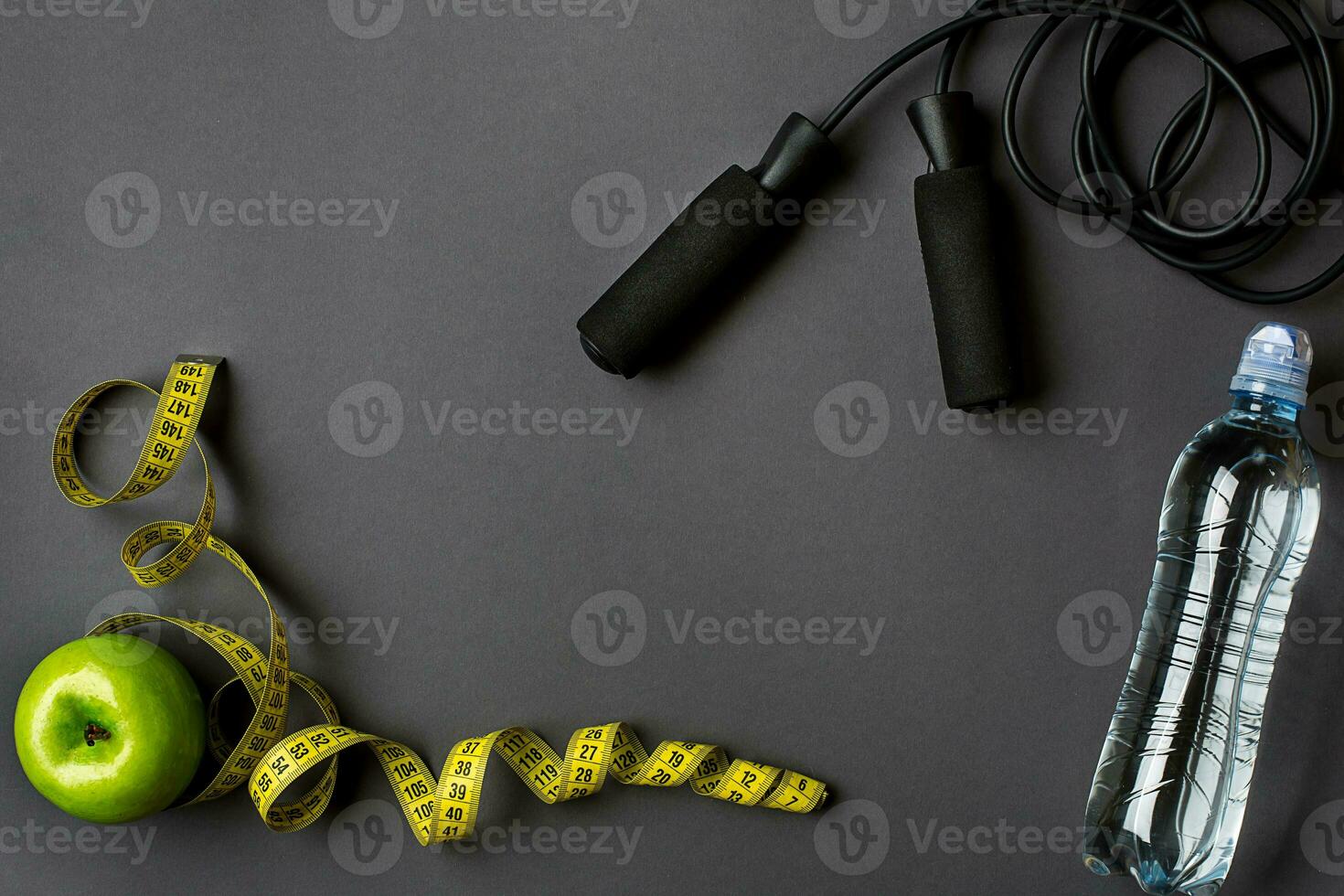 Athlete's set with bottle of water on dark gray background photo