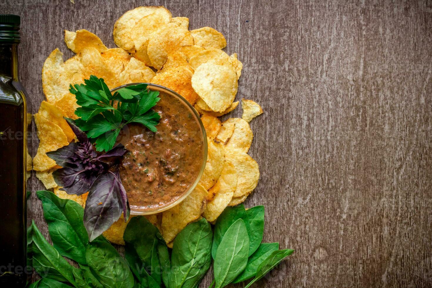 Potato chips with dipping sauce on a wooden table. Unhealthy food on a wooden background. photo