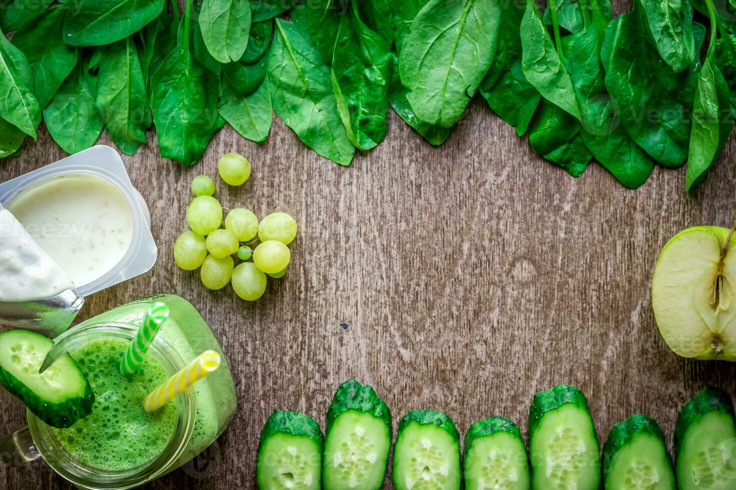 Green smoothie with apples, yogurt, spinach, cucumber on wooden background photo