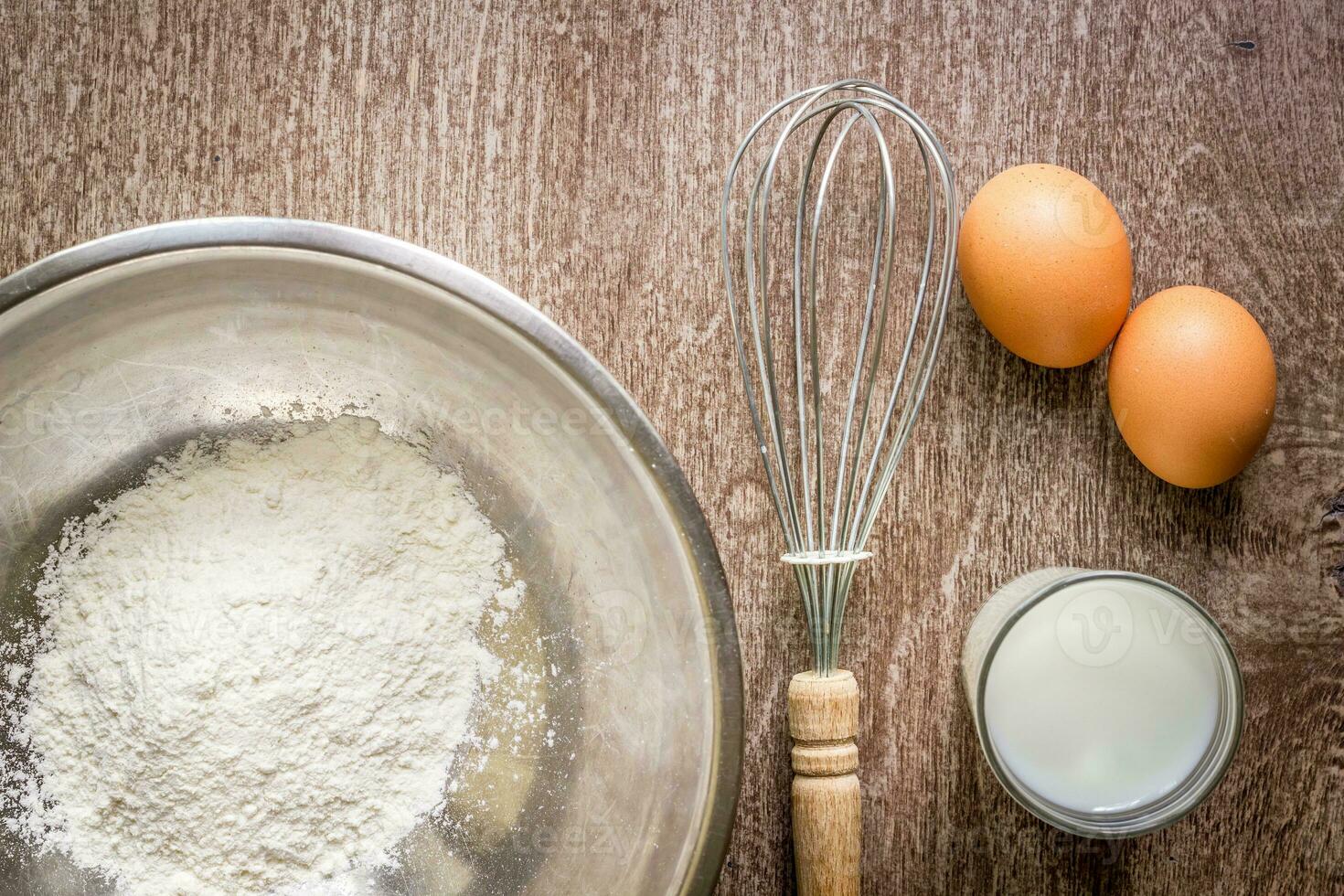 Food ingredients and kitchen utensils for cooking on wooden background photo