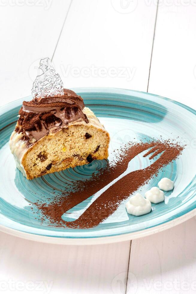 Small cake with different stuffing on a blue plate. White wooden table. photo