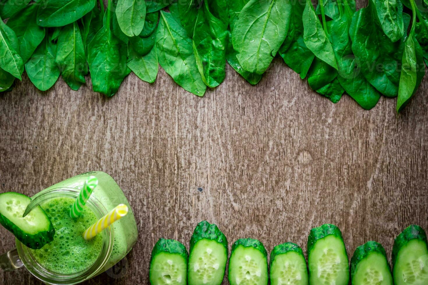 Glass of spinach juice on wooden background photo