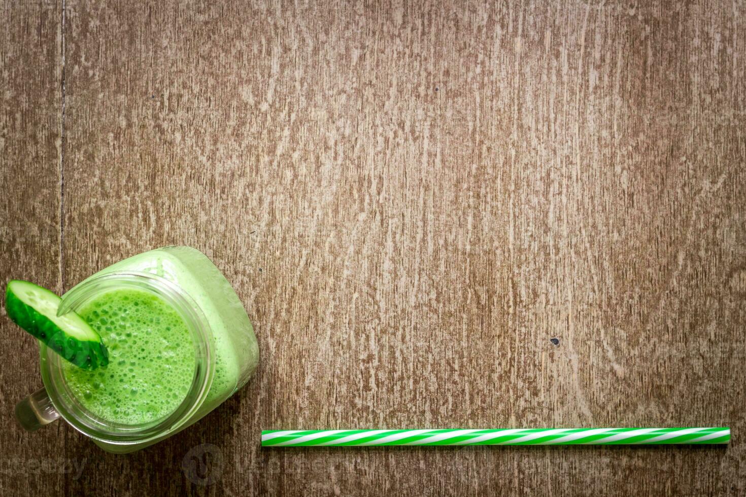 Glass of spinach juice on wooden background photo