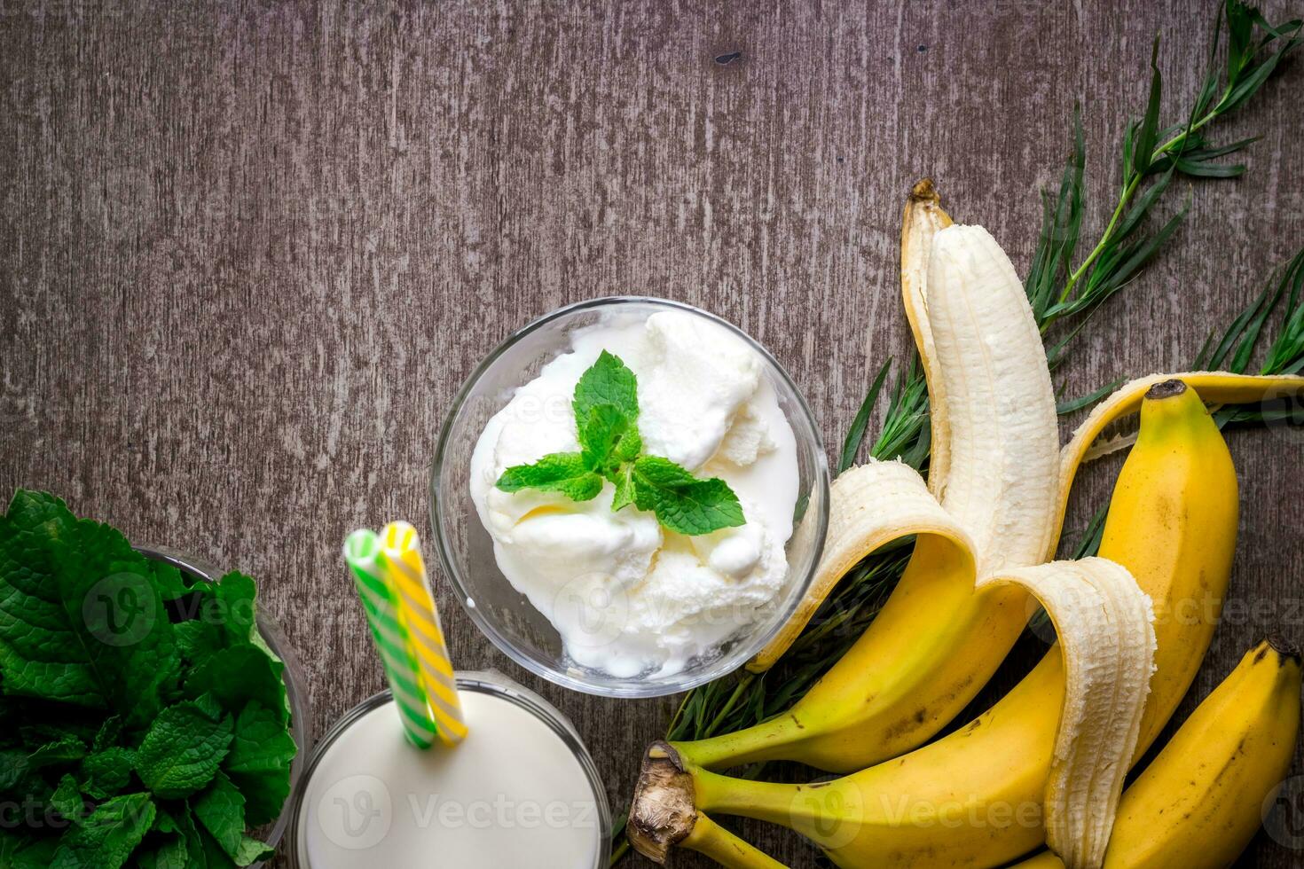 Ice cream with fresh banana and mint on wooden table. photo