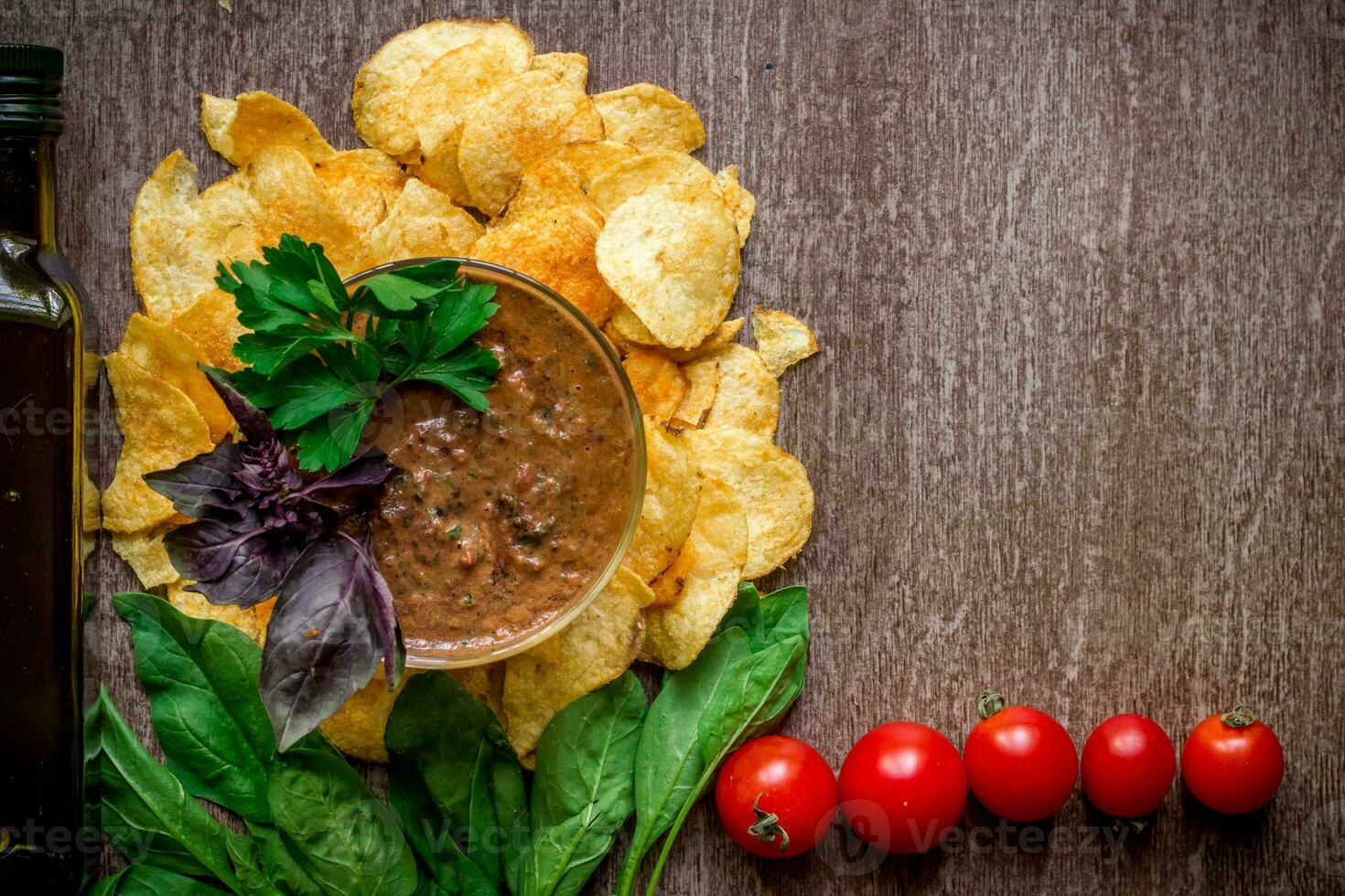 Potato chips with dipping sauce on a wooden table. Unhealthy food on a wooden background. photo