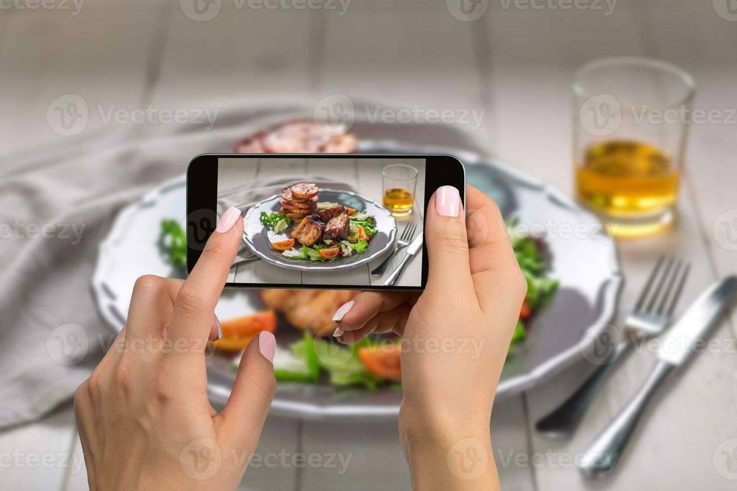 fotografiando comida concepto - mujer toma imagen de caliente carne platos. Cerdo costillas A la parrilla con ensalada y manzanas en un lámina. foto