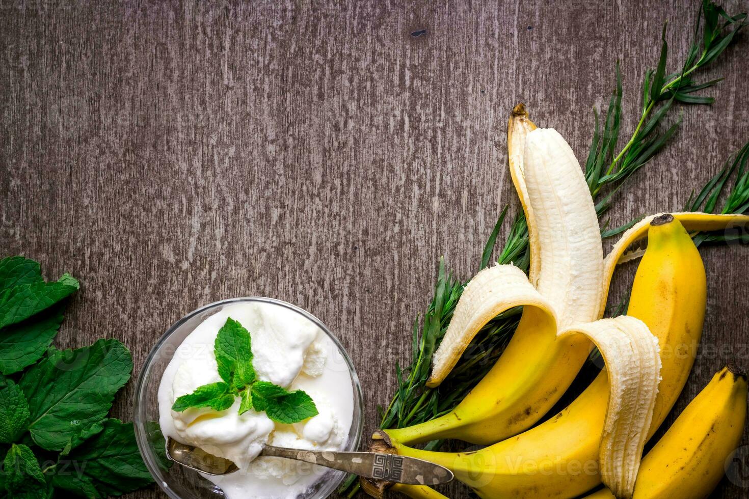 hielo crema con Fresco plátano y menta en de madera mesa. foto