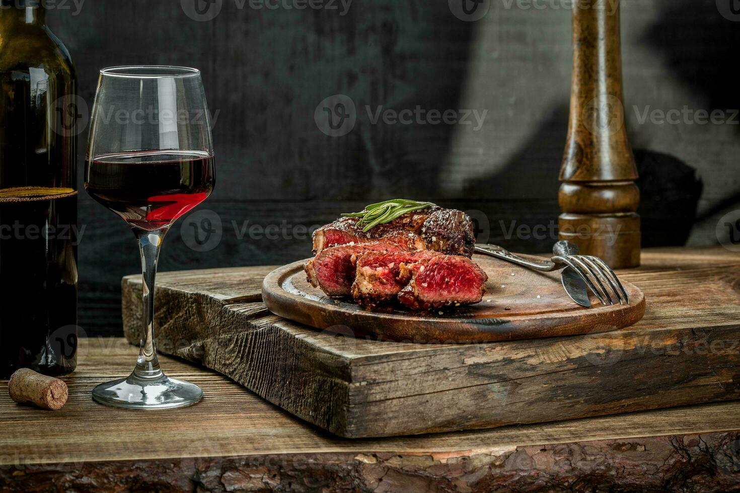 Grilled ribeye beef steak with red wine, herbs and spices on wooden table photo