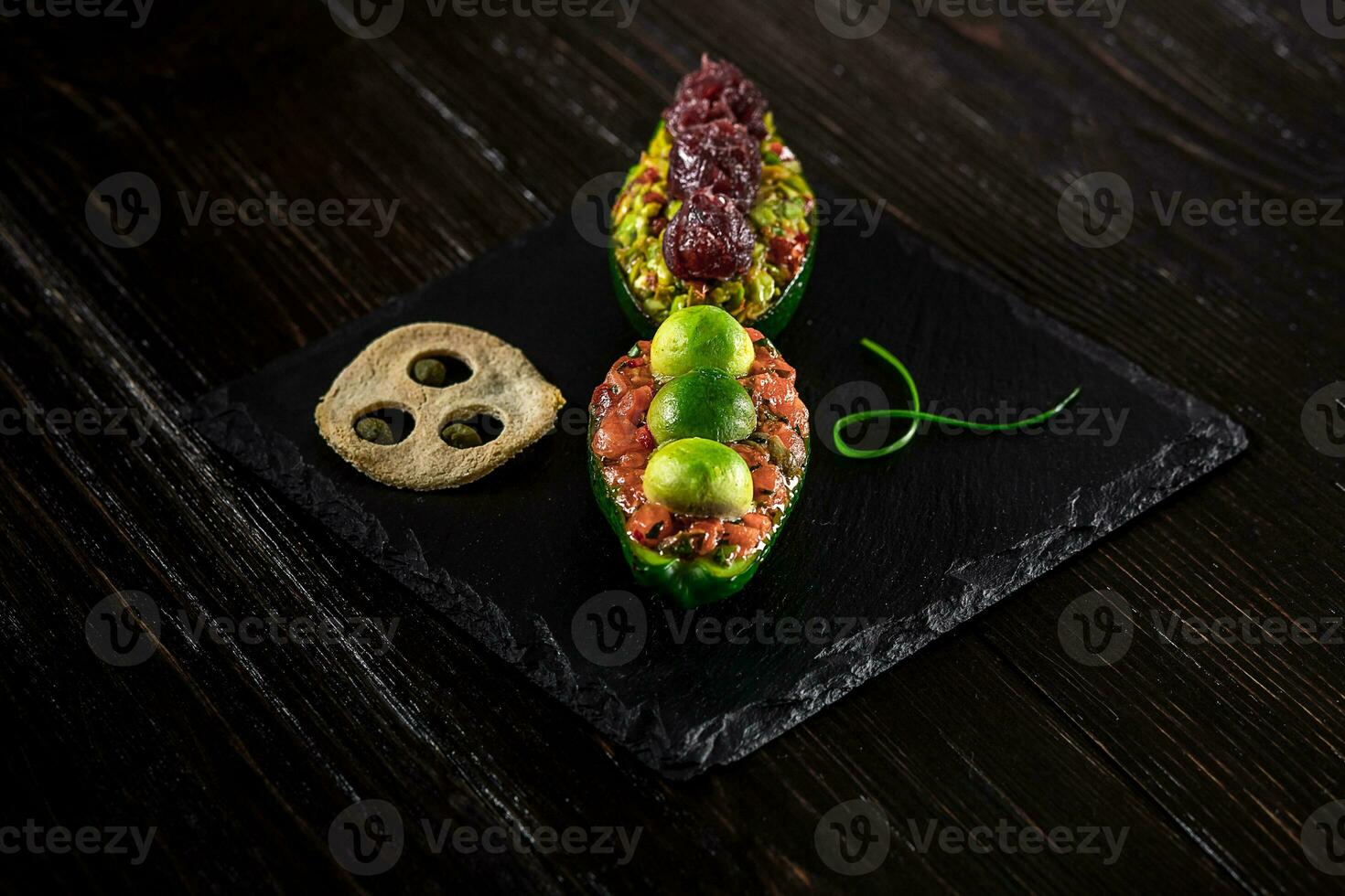 Salmon tartare and avocado salad on a black background photo