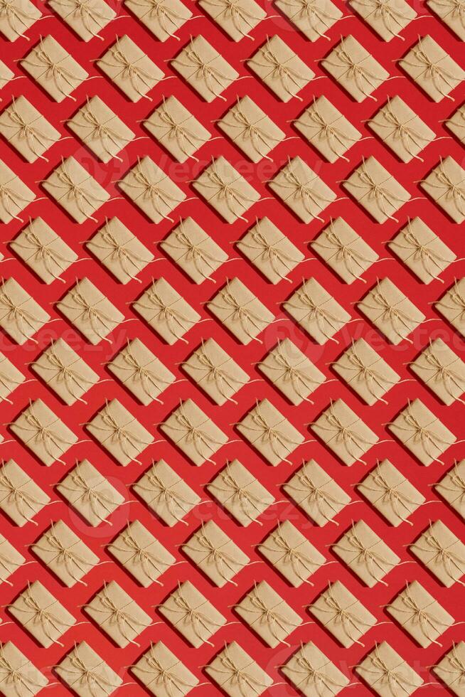 Craft paper present boxes tied from rope on red background. Pattern photo