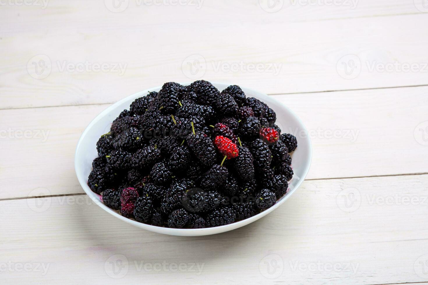 mulberry in white plate, top view photo