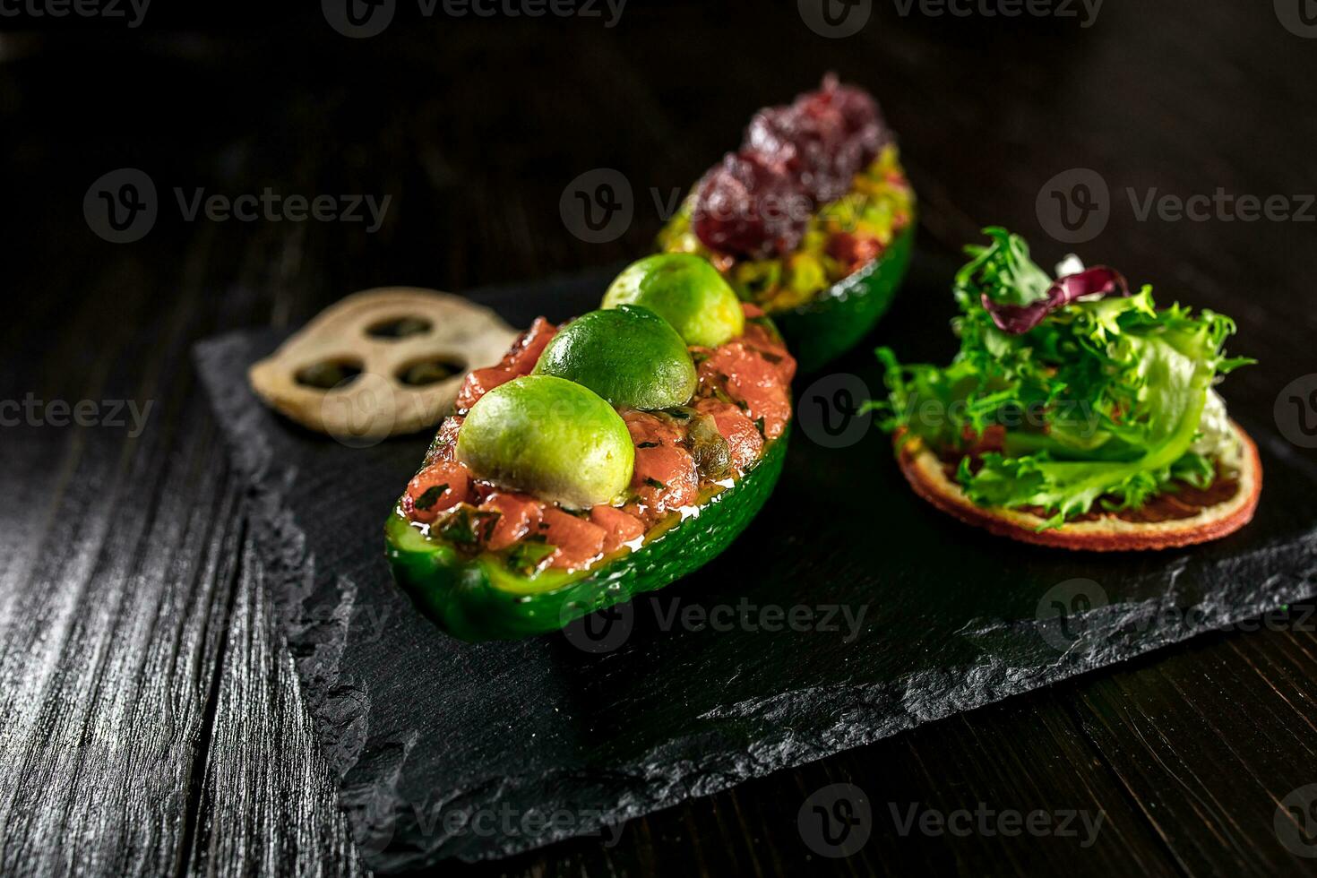 salmón tartar y aguacate ensalada en un negro antecedentes foto