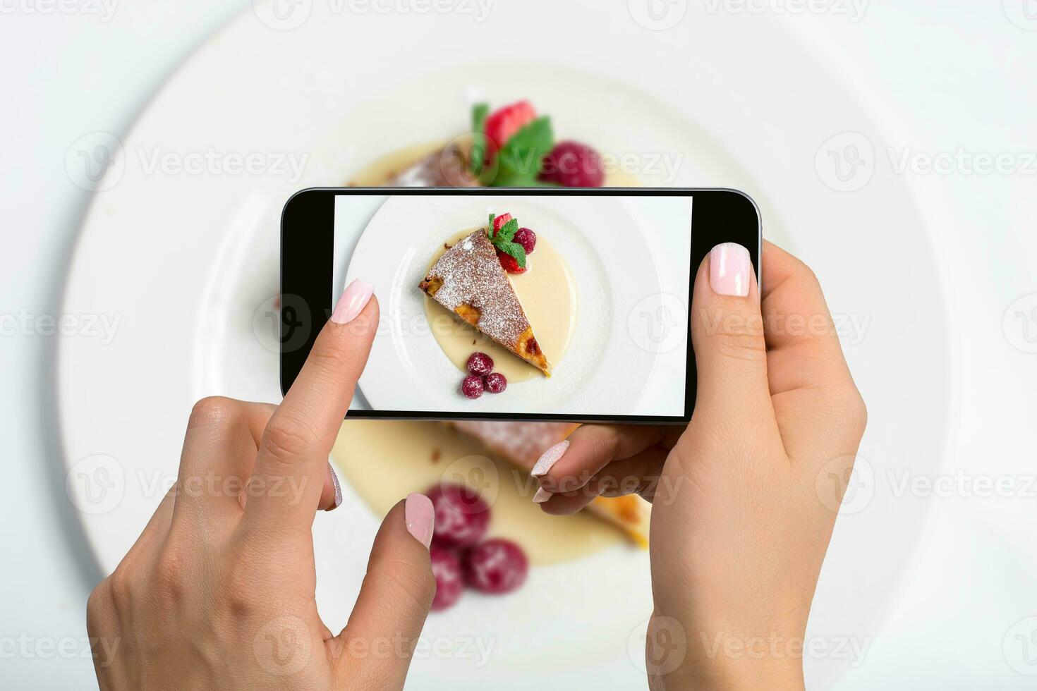 Shooting food on phone's camera. Raspberry Cheesecake on a plate. Food Photographer photo