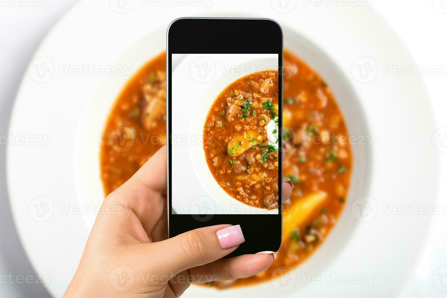 Smartphone camera hand point shoot photo soup. Food photograph. Made for social networks.