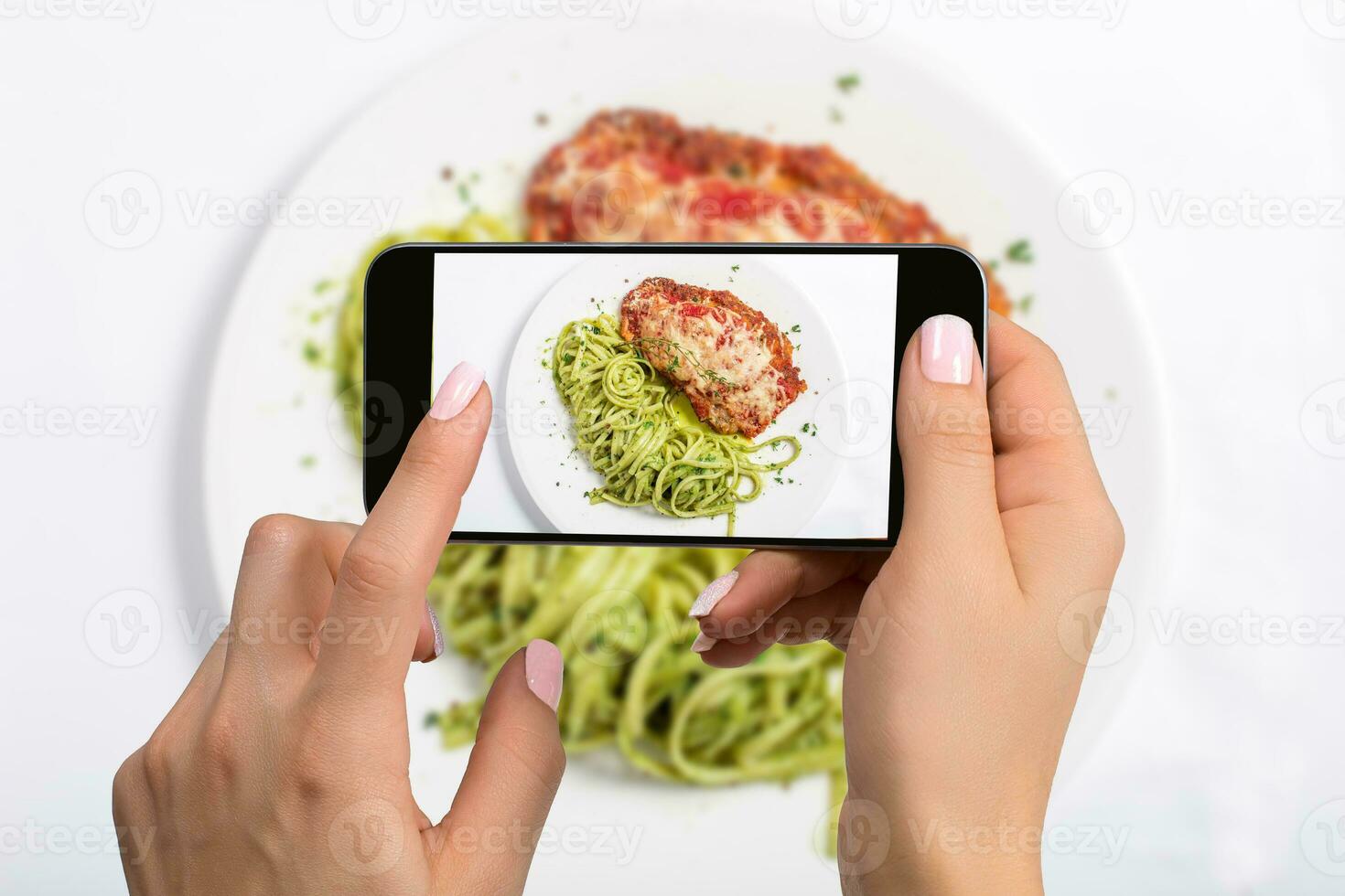 A young woman taking photo of food on smartphone, photographing meal with mobile camera