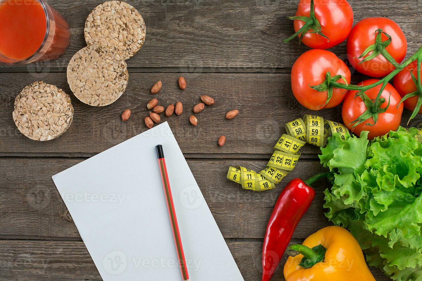 Glass of tomato juice with vegetables and measuring tape on table close-up photo