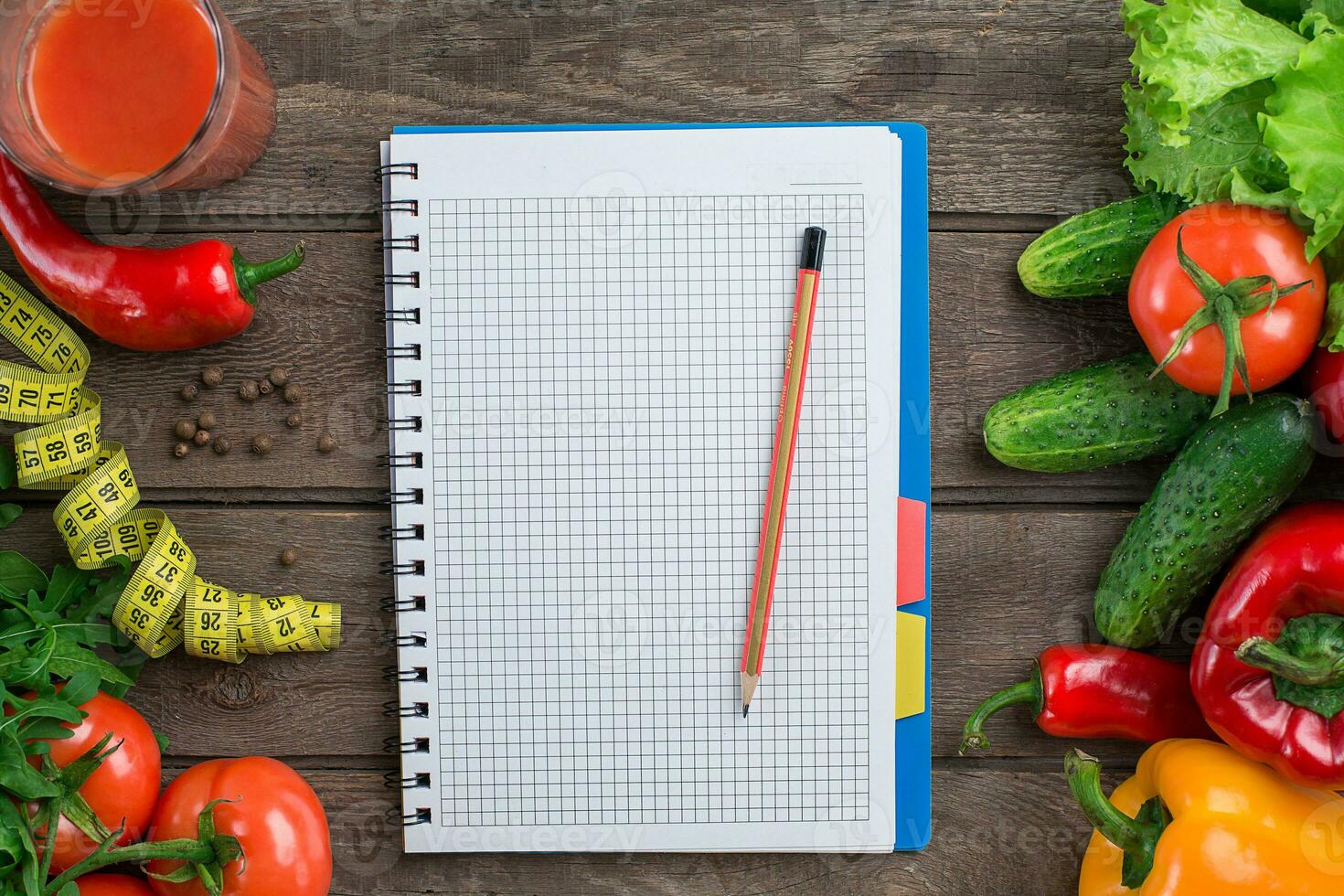 Glass of tomato juice with vegetables and measuring tape on table close-up photo