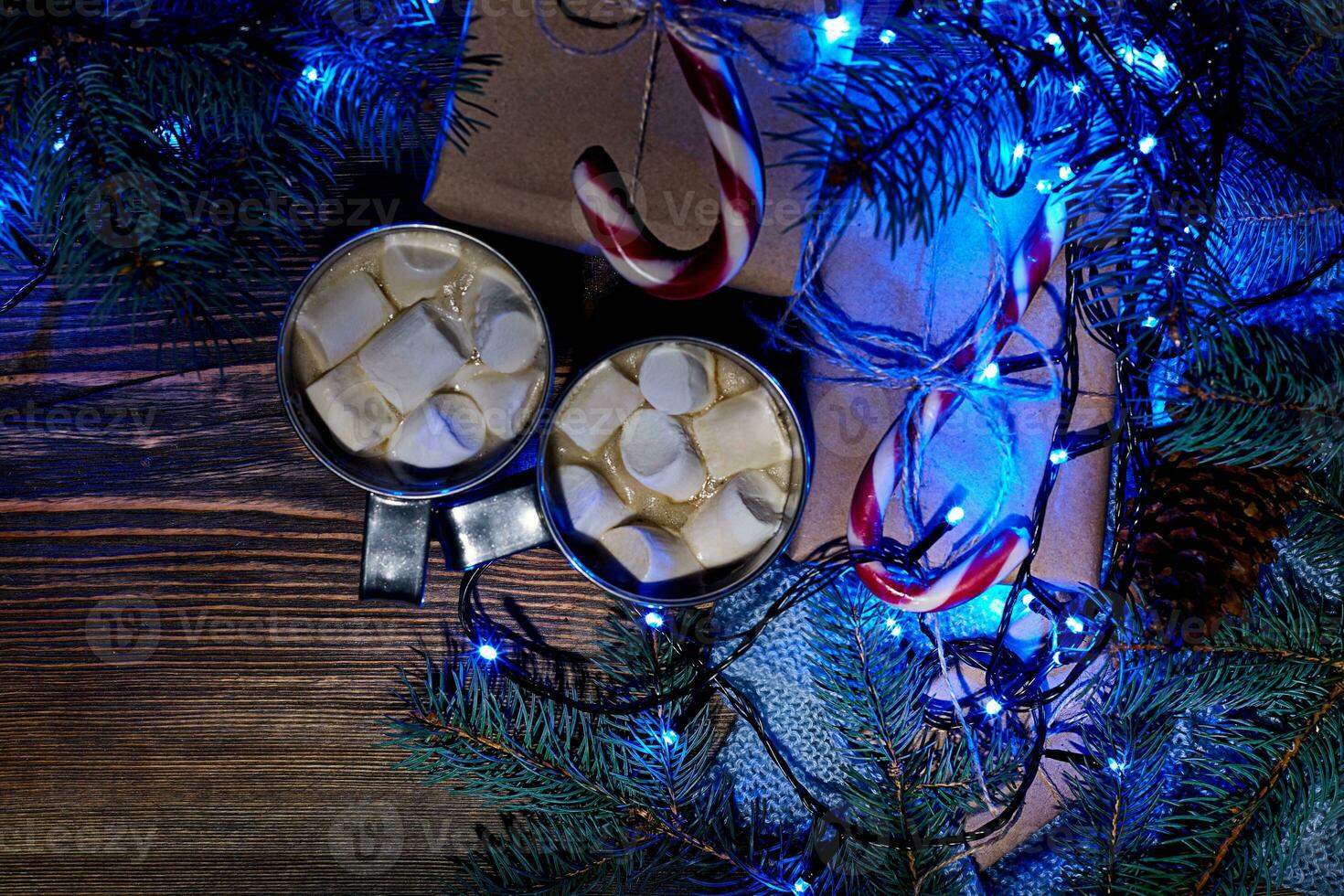 Christmas hot drink. Cocoa with marshmallow, garland and spruce branches on a wooden background. Top view photo