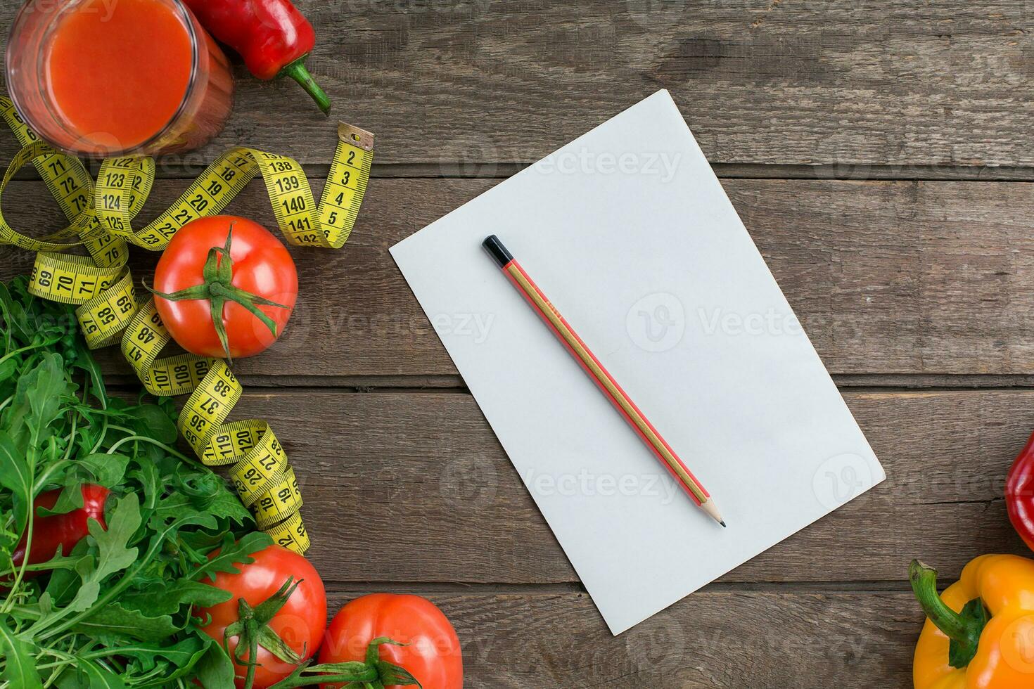 Glass of tomato juice with vegetables and measuring tape on table close-up photo