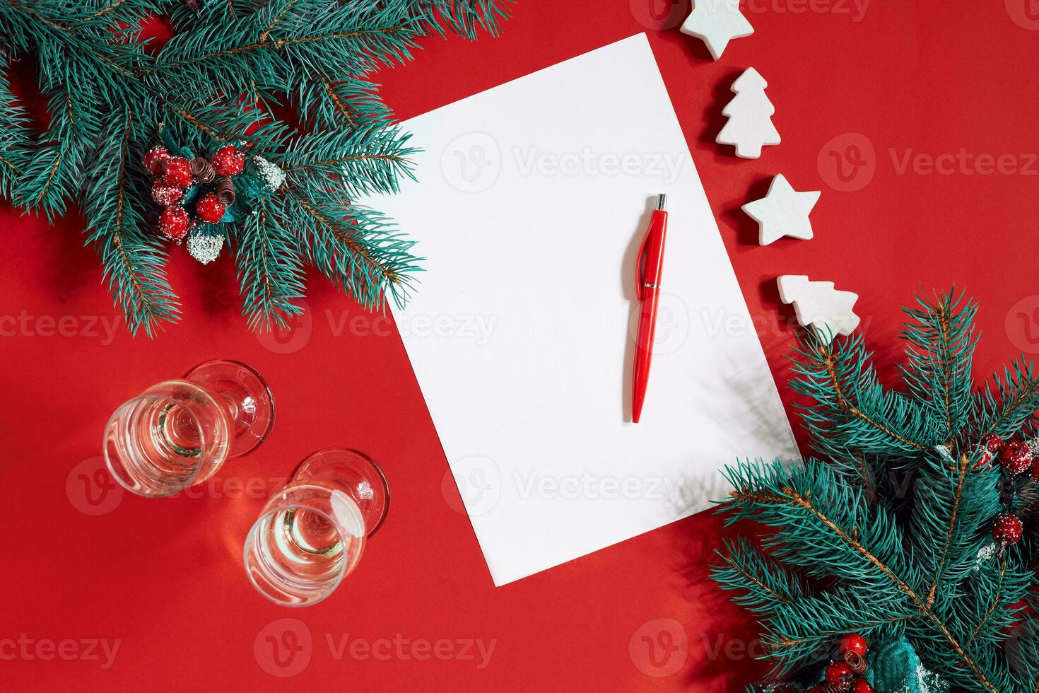 Red pen and notepad on red table decorated with a fir branch. The background for the text. photo