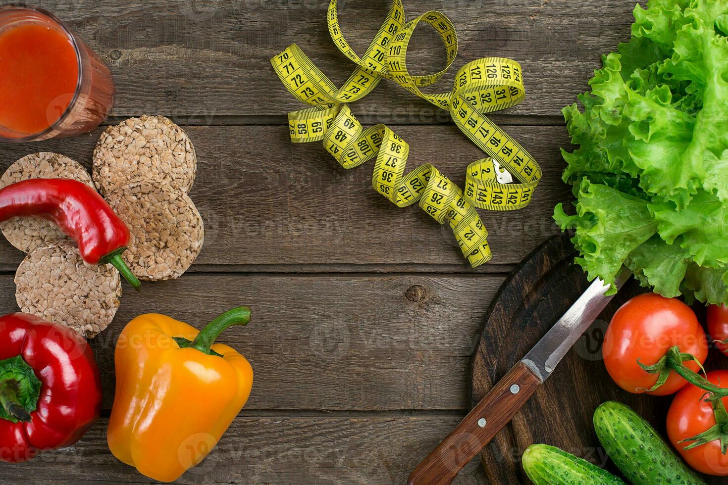 Glass of tomato juice with vegetables and measuring tape on table close-up photo