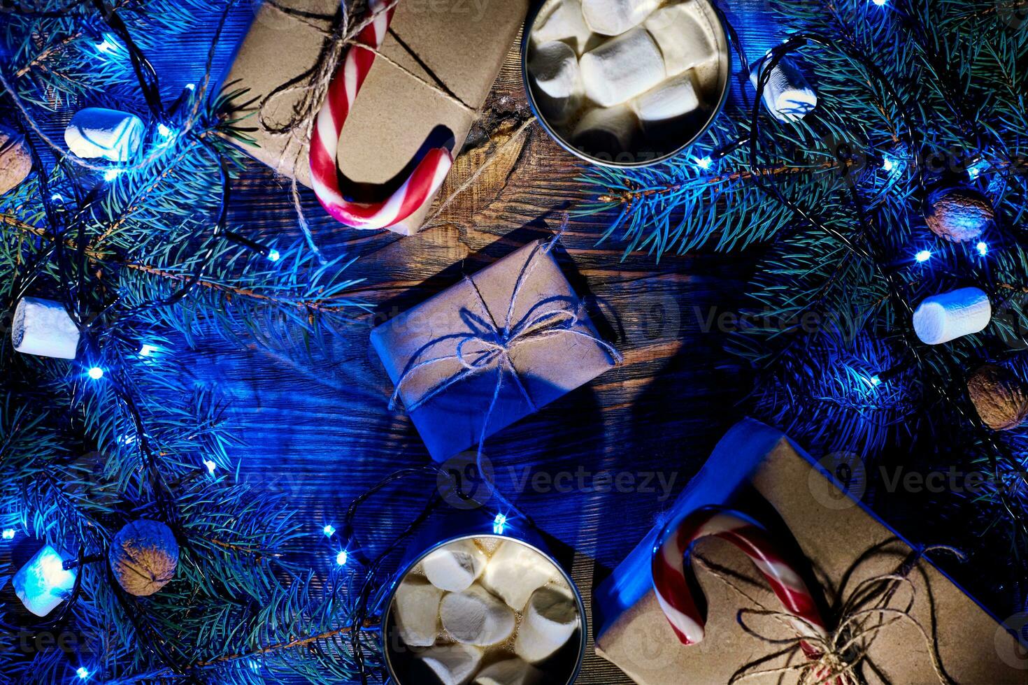 Christmas hot drink. Cocoa with marshmallow, garland and spruce branches on a wooden background. Top view photo