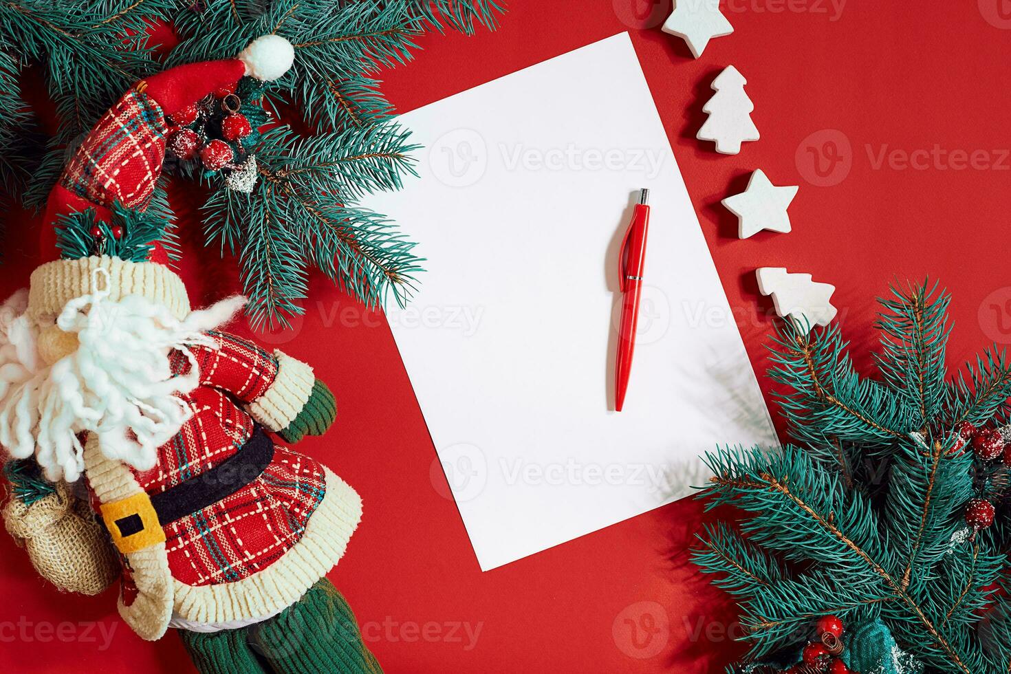 Red pen and notepad on red table decorated with a fir branch. The background for the text. photo